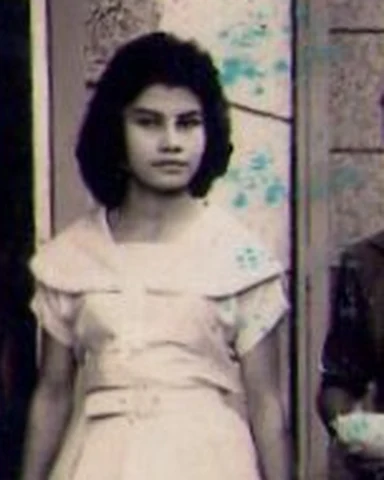 Dolly joven, con vestido blanco, caminando por la calle
